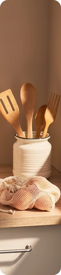Kitchen utensils, egg carton, and wooden spoons on a wooden counter