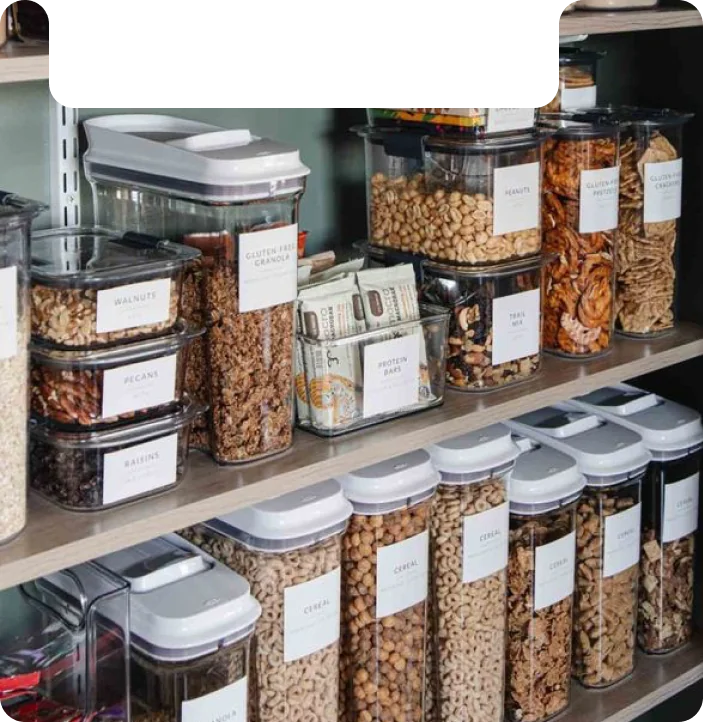 Organized pantry with clear containers of granola, nuts, cereal, and dried fruits